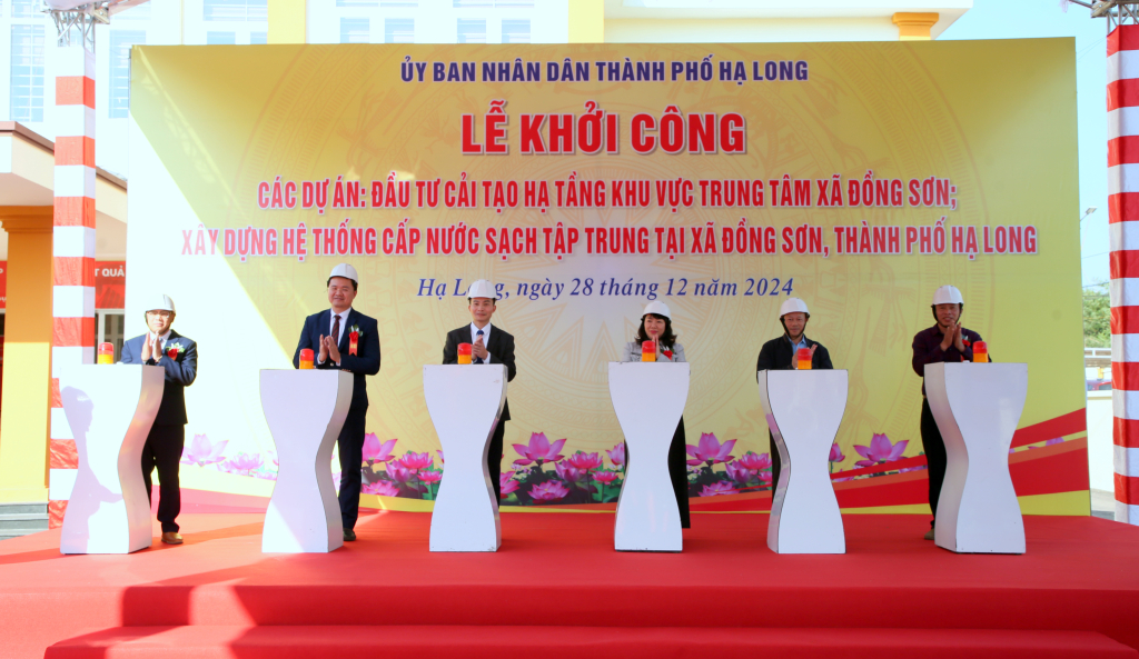 Các đại biểu thực hiện nghi thức khởi công Dự án Đầu tư cải tạo hạ tầng khu vực trung tâm xã Đồng Sơn và Dự án Xây dựng hệ thống cấp nước sạch tập trung tại xã Đồng Sơn.