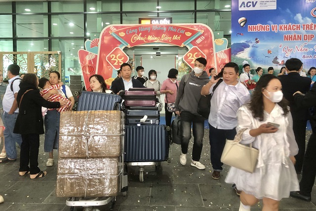 Những vị khách đầu tiên bước qua “cổng chào” Cảng Hàng không Phù Cát. Ảnh: VH Những vị khách đầu tiên bước qua “cổng chào” Cảng Hàng không Phù Cát. Ảnh: VH