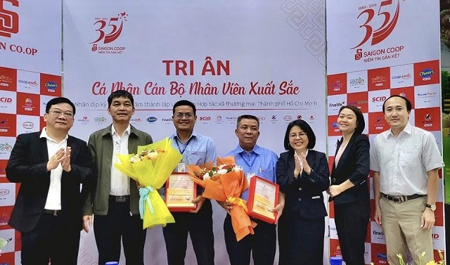 Ông Thái Lương Hùng (bài trái) trao tặng giấy khen và hoa cho các cán bộ, nhân viên thuộc hệ thống Saigon Co.op. Ảnh: VM