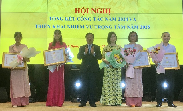 Ông Nguyễn Tuấn Thanh (thứ 3 từ trái qua) trao Bằng khen của UBND tỉnh Bình Định cho 5 cán bộ, công chức Sở Tài chính Bình Định. Ảnh VH