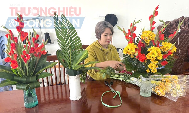 Chị Hồ Nguyệt cắm hoa chuẩn bị Tết trên bàn thờ gia đình
