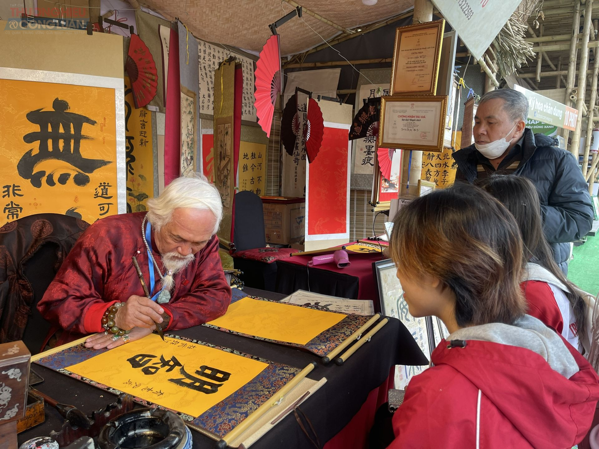 Cụ đồ Nguyễn Văn Tư đang viết chữ.... cho khách bên Hồ Văn với giá 150.000 đồng - 200.000 đồng