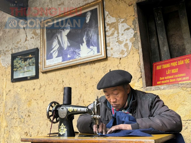 Cụ ông người Mông đang may trang phục dân tộc tại nhà của Pao.