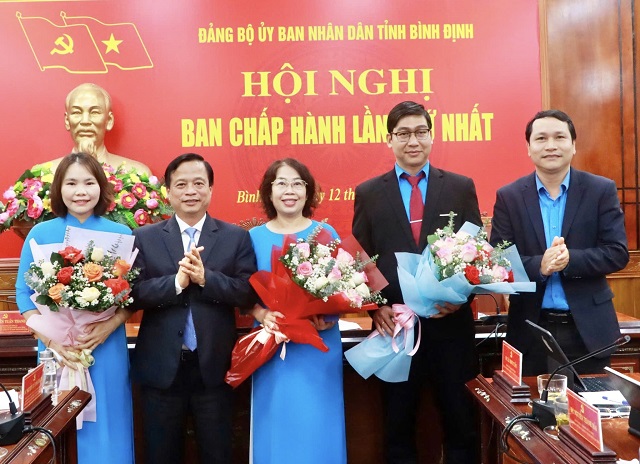 Ông Nguyễn Tuấn Thanh, Phó bí thư Đảng uỷ UBND tỉnh Bình Định (thứ 2 từ trái qua) trao quyết định và tặng hoa chúc mừng các vị lãnh đạo Chi bộ Công đoàn UBND tỉnh. Ảnh: VH