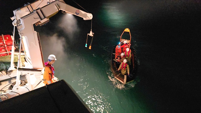 Nhân viên cứu nạn chuyển ngư dân bị tai nạn từ tàu cá lên tàu SAR 274 trong đêm 11-2 - Ảnh: Vietnam MRCC