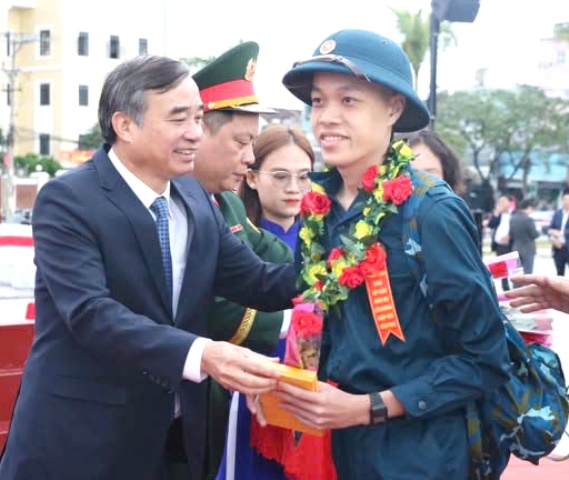 Ông Lê Trung Chinh, Chủ tịch UBND TP Đà Nẵng, tặng quà, chúc mừng thanh niên nhập ngũ.