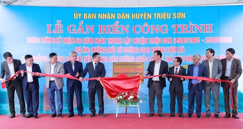 Các đại biểu thực hiện nghi thức gắn biển công trình Đường nối từ đường giao thông liên xã Cầu Trắng - Đồng Lợi, xã Tiến Nông đến Quốc lộ 47C, xã Vân Sơn.