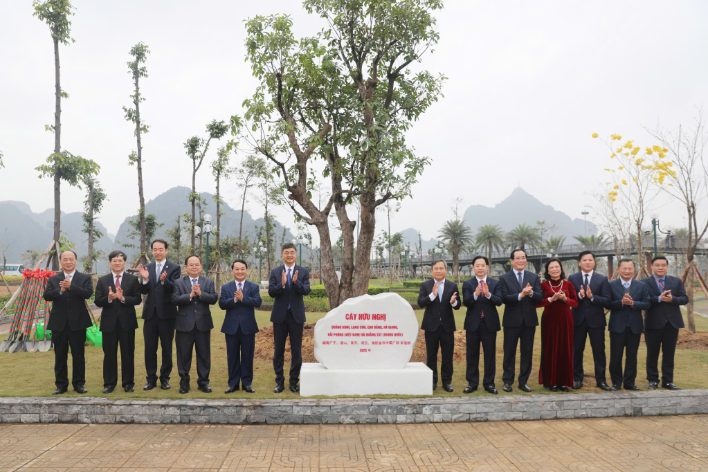 Các đại biểu chụp ảnh lưu niệm bên cây hữu nghị.