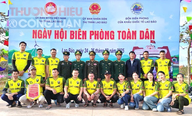 Đội bóng chuyền nam Đại đội Biên phòng 320/Lào (áo vàng) lần đầu tiên tham dự Ngày hội Biên phòng toàn dân chụp ảnh lưu niệm.