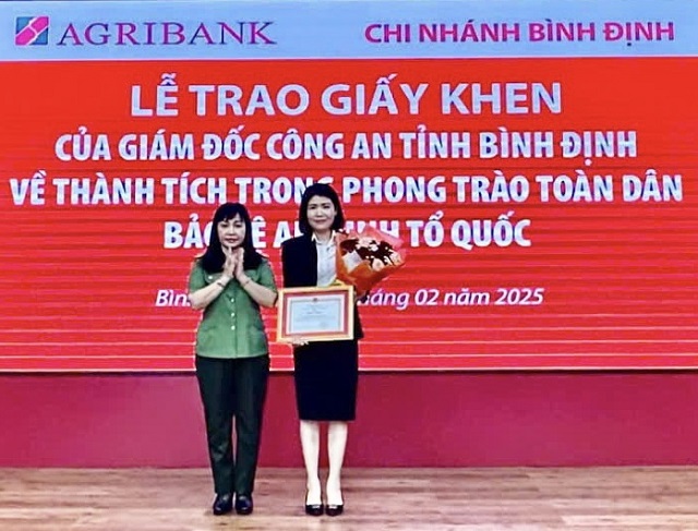 Giao dịch vi&ecirc;n Nguyễn L&acirc;m Thanh Thủy (b&ecirc;n phải) nhận Giấy khen của Gi&aacute;m đốc C&ocirc;ng an tỉnh B&igrave;nh Định. Ảnh: T-Lu&acirc;n