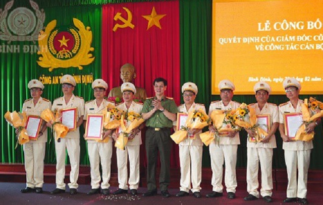Đại tá Ngô Cự Vinh, Phó Giám đốc Công an tỉnh (đứng giữa) trao Quyết định, tặng hoa chúc mừng các đồng chí nhận quyết định của Giám đốc Công an tỉnh về công tác cán bộ. Ảnh: Q- Hùng