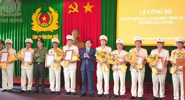 Ông Hồ Quốc Dũng (áo vét, đứng giữa) tặng hoa chúc mừng các cán bộ nhận Quyết định về công tác tại Công an tỉnh. Ảnh: Q-Hùng