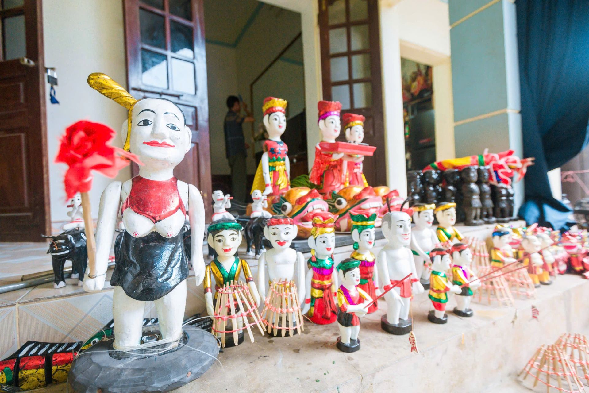 Con rối làm bằng gỗ được đục đẽo với những đường nét cách điệu riêng sau đó gọt giũa, đánh bóng và trang trí với nhiều màu sơn khác nhau để làm tôn thêm đường nét, tính cách cho từng nhân vật.