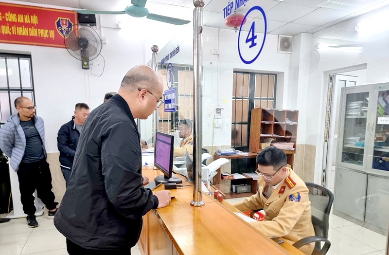 Người dân làm đăng ký xe tại điểm đăng ký, cấp biển số xe số 342 phố Thái Hà, quận Đống Đa, Hà Nội. Ảnh Thành Long.