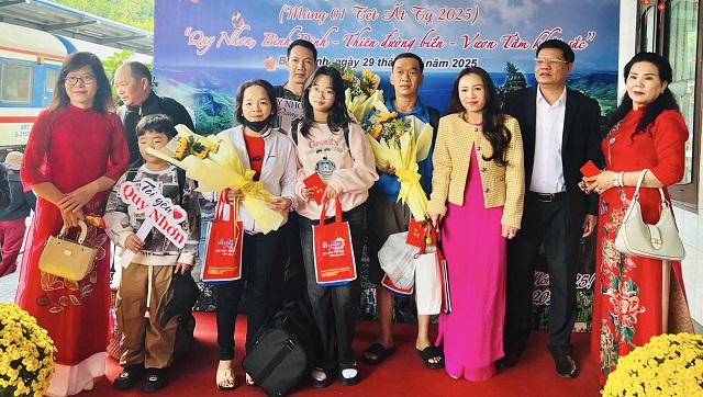 Lãnh đạo ngành VH-TT&DL Bình Định tặng hoa chúc mừng du khách đến Bình Định bằng phương tiện tàu hoả. Ảnh: Trung Thành.