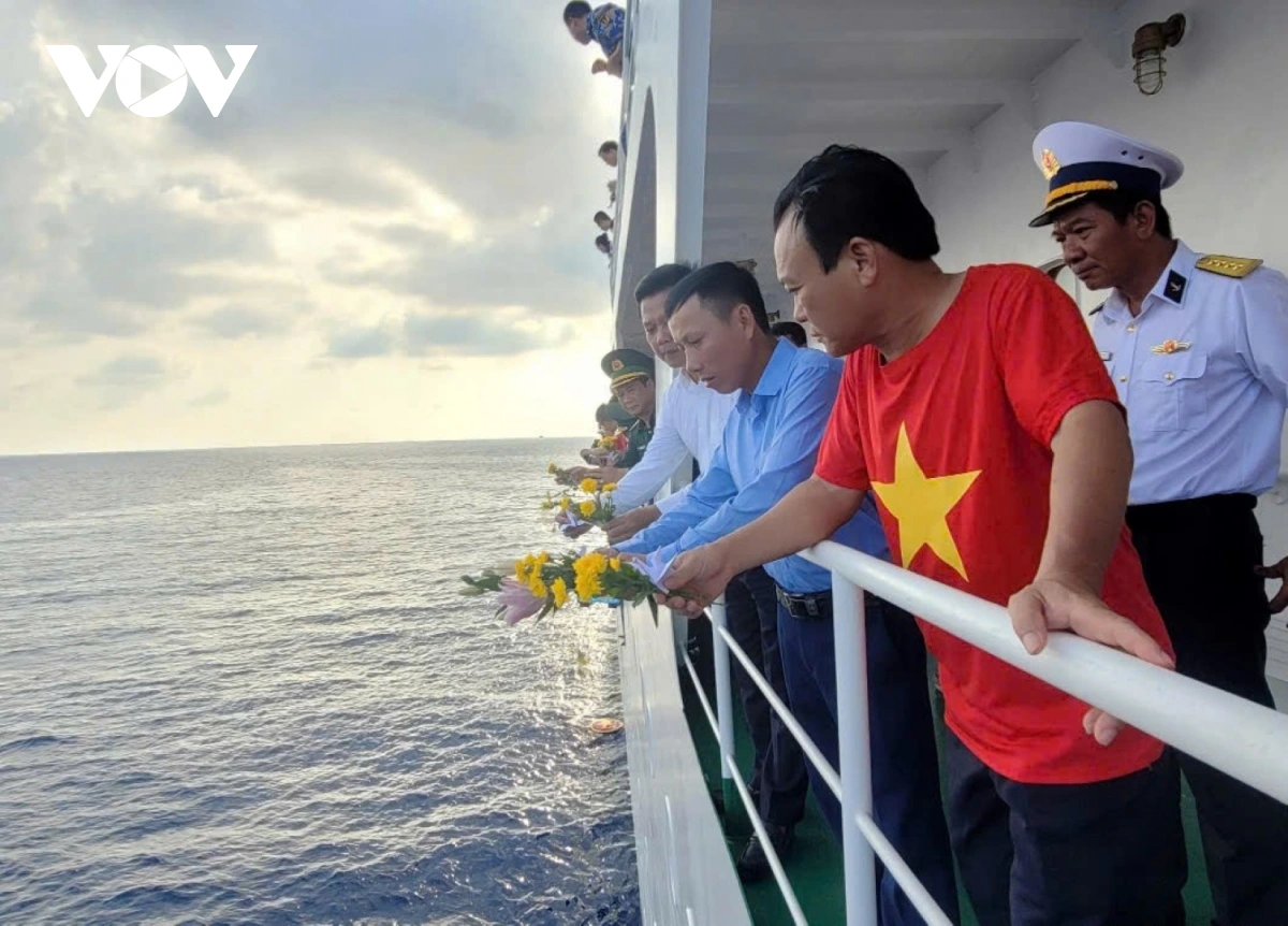 Anh Nguyễn Đình Thế (mặc áo xanh) cùng đoàn công tác thả hoa tri ân liệt sĩ Gạc Ma