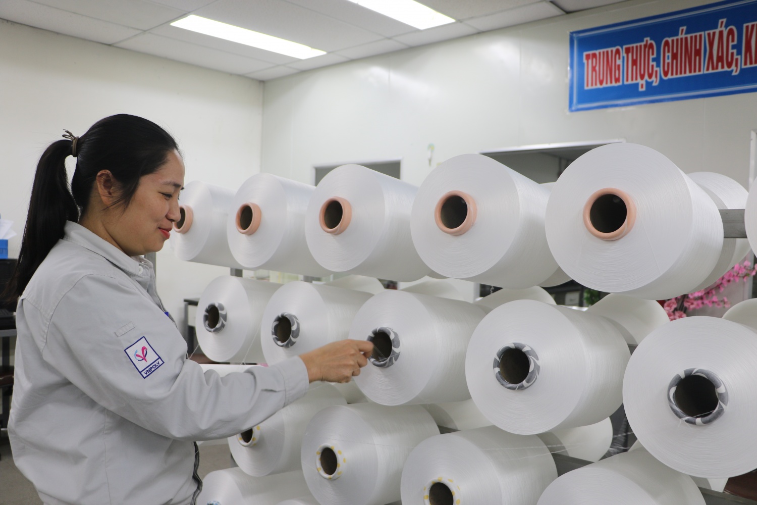 Công nhân vận hành dây chuyền sản xuất sợi DTY của VNPoly say sưa trong công việc Công nhân vận hành dây chuyền sản xuất sợi DTY của VNPoly say sưa trong công việc