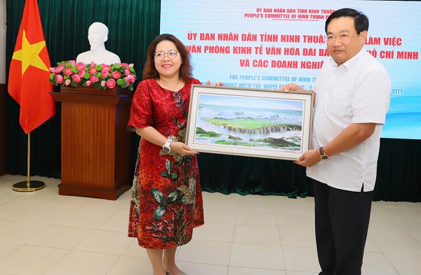 ông Trịnh Minh Hoàng, Phó Chủ tịch UBND tỉnh Ninh Thuận tặng ảnh lưu niệm cho bà Trần Thị Hải Yến, Giám đốc Trung tâm Xúc tiến Đầu tư phía Nam thuộc Cục Đầu tư nước ngoài, Bộ Tài chính.