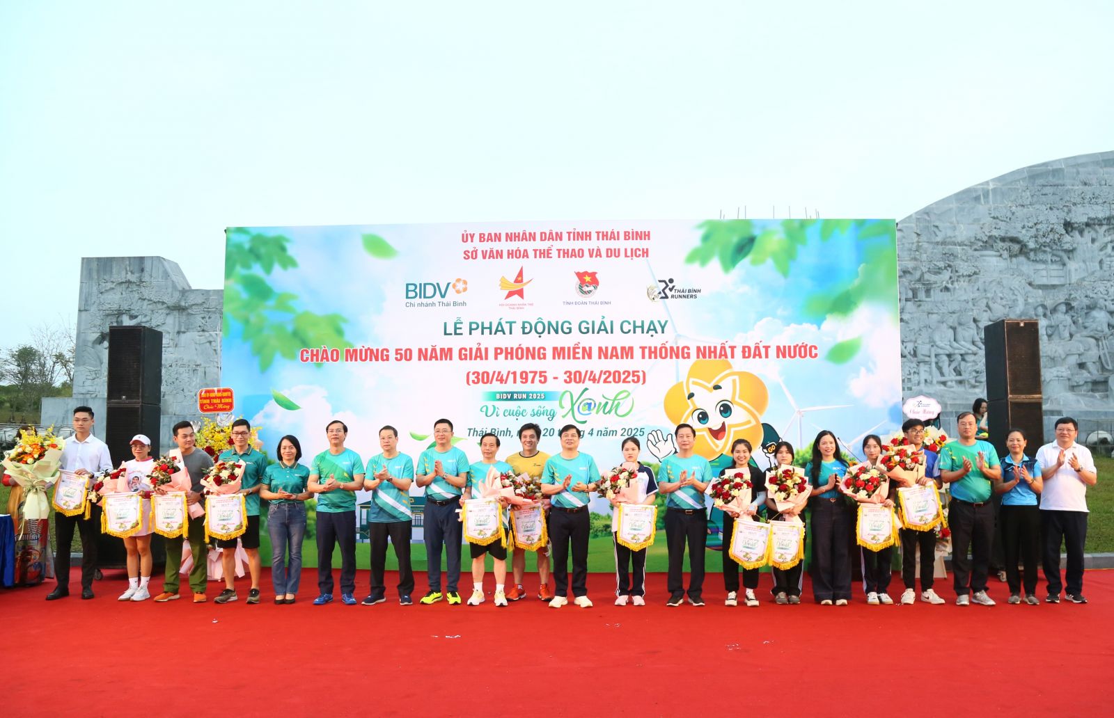 Các đồng chí lãnh đạo tỉnh và đại diện các sở, ngành, đơn vị trao cờ lưu niệm và tặng hoa các đơn vị tham gia giải chạy.