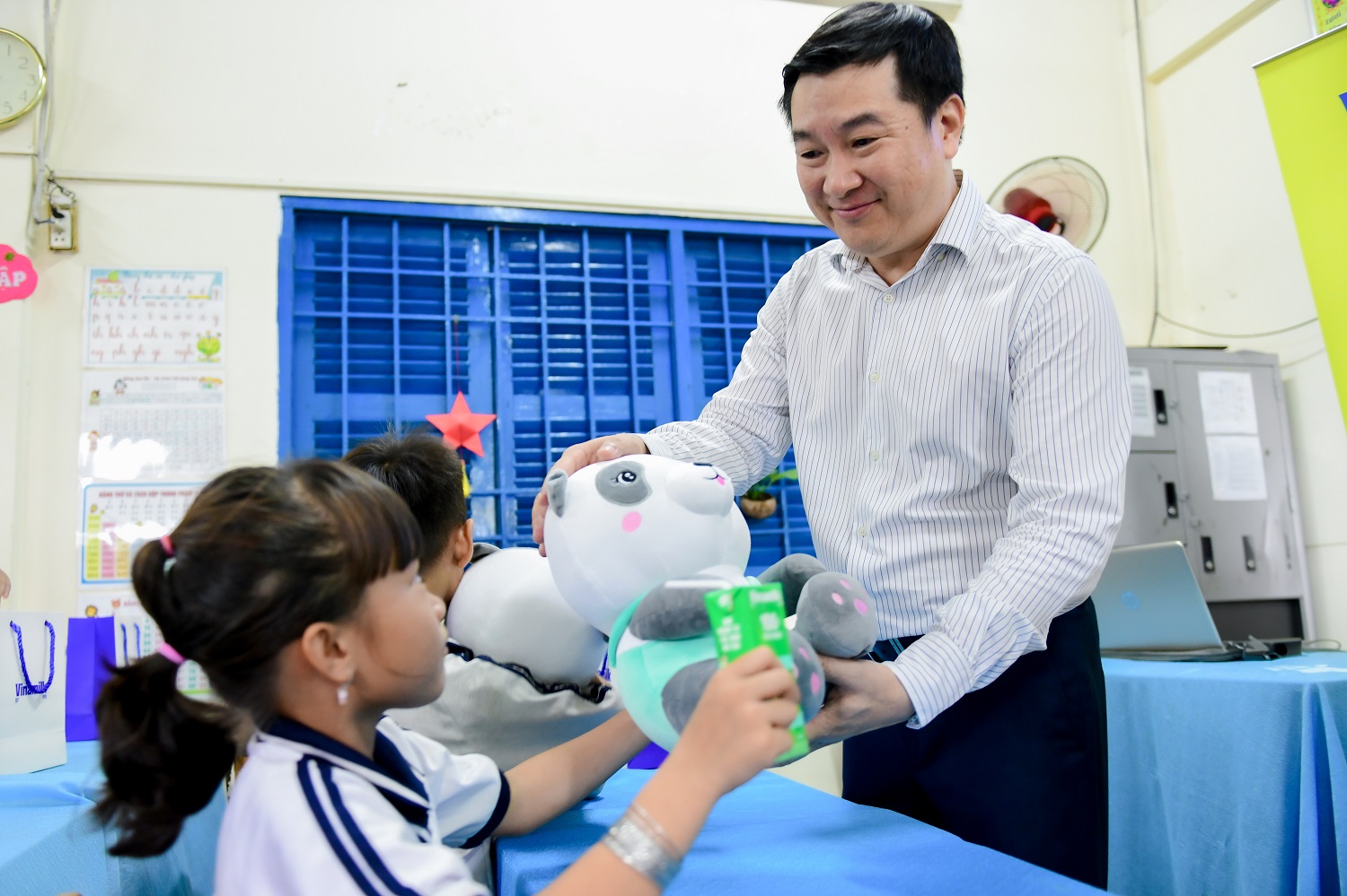 Các em học sinh đón nhận sữa, gấu bông và các món quà khác từ Vinamilk. Các em học sinh đón nhận sữa, gấu bông và các món quà khác từ Vinamilk.