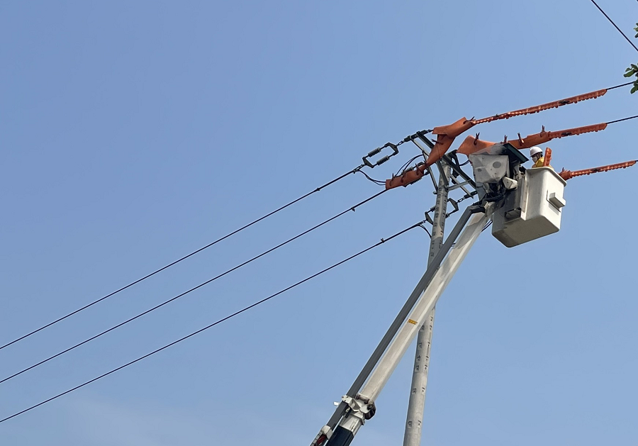 Công nhân Điện lực Phủ Lý thay sứ trên lưới 22kV đang mang điện