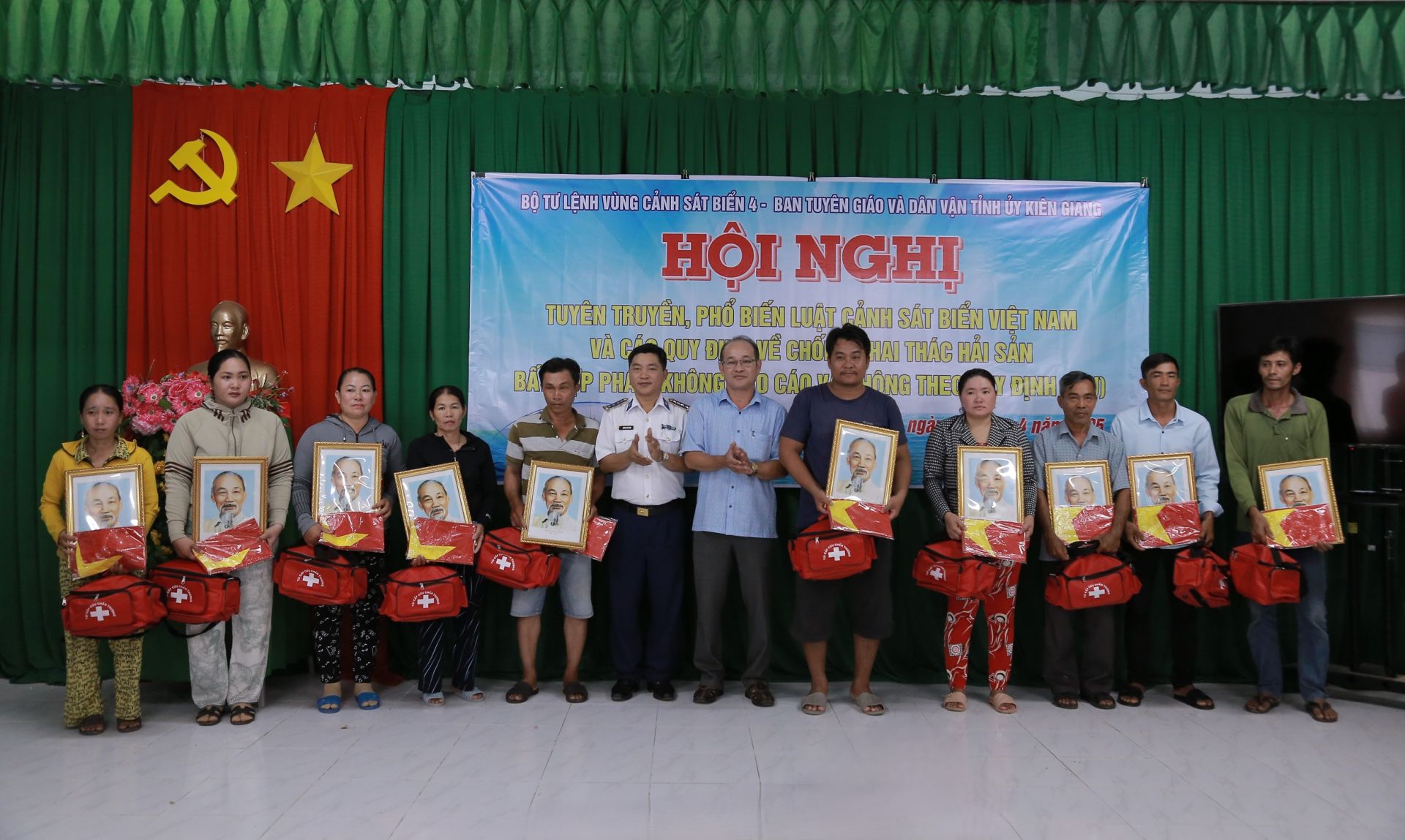Đại diện Bộ Tư lệnh Vùng Cảnh sát biển 4 và đại diện lãnh đạo địa phương tặng Cờ Tổ quốc, ảnh Bác Hồ và túi thuốc y tế cho ngư dân trên địa bàn xã Đông Hưng A, huyện An Minh.