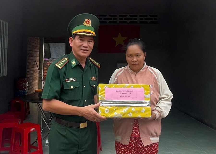 Đại tá Vũ Minh Tùng, Phó Chính ủy BĐBP tỉnh tặng quà cho hộ gia đình ông Phạm Chí Hiền.