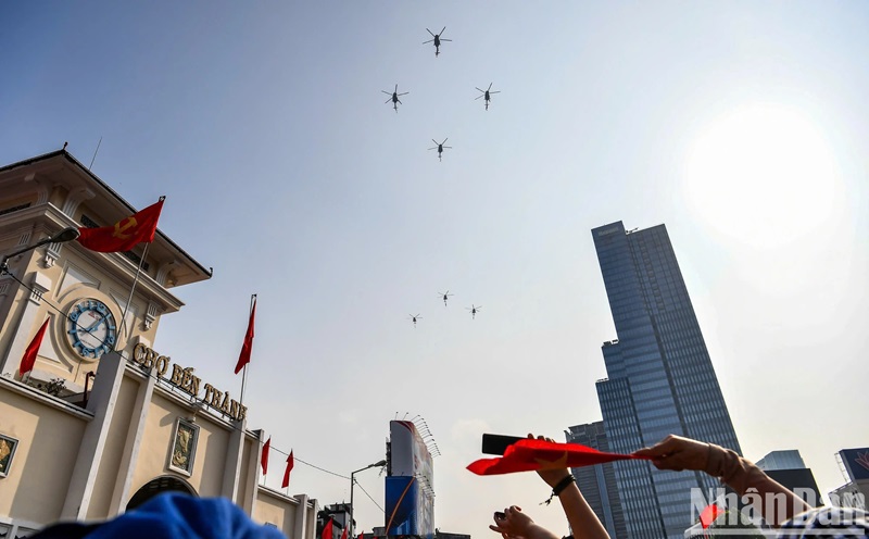 Người dân ngắm nhìn máy bay trực thăng bay qua khu vực chợ Bến Thành