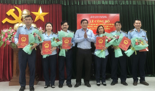 Lãnh đạo các Đội QLTT nhận Quyết định bổ nhiệm từ Giám đốc Sở Công Thương Bình Định (đứng giữa). Ảnh: Viết Hiền