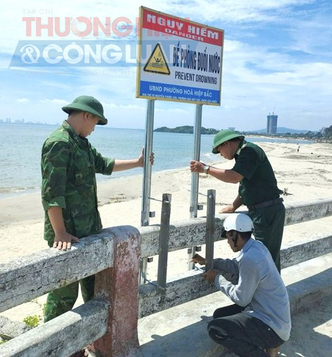Cán bộ Đồn Biên phòng Hải Vân (BĐBP thành phố Đà Nẵng) cắm biển khu vực nguy hiểm cảnh báo người dân và du khách