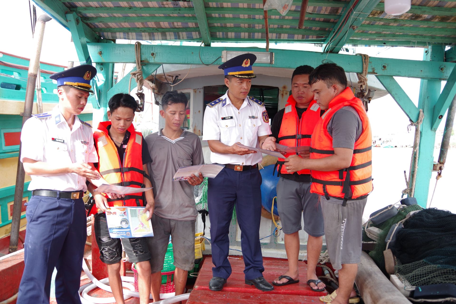 Cán bộ chiến sĩ Cảnh sát biển thuộc Hải đoàn 42, BTL Vùng Cảnh sát biển 4 tuyên truyền, phổ biến pháp luật cho ngư dân trên tàu cá