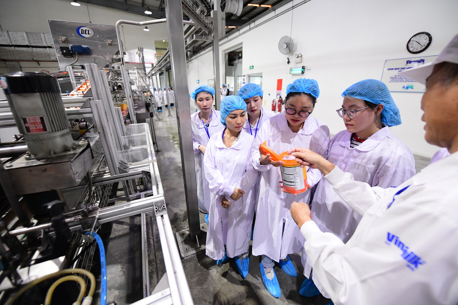 Người tiêu dùng thích thú với những lon sữa tinh khiết vừa “ra lò” trong nhà máy.