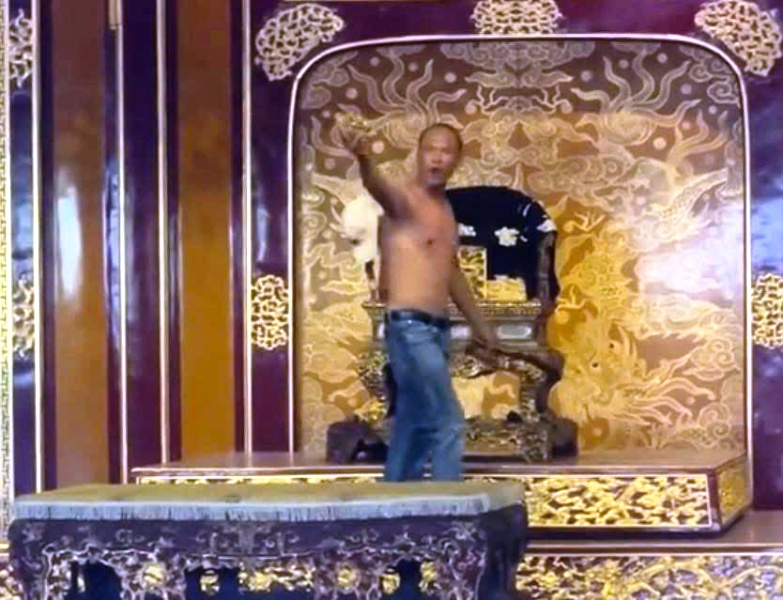 Người đàn ông bẻ tay vịn bên trái Ngai Vu cầm trên tay Người đàn ông bẻ tay vịn bên trái Ngai Vu cầm trên tay