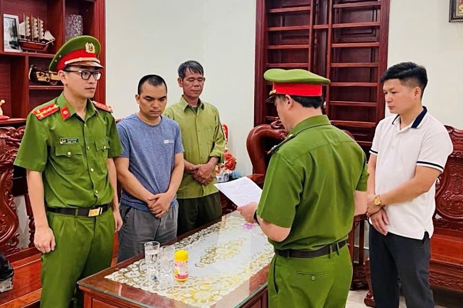 Cơ quan Cảnh sát điều tra Công an tỉnh Quảng Bình tống đạt quyết định khởi tố, lệnh bắt tạm giam đối với Lê Thế Hải (áo phông xanh cổ tròn), Giám đốc Công ty TNHH cung ứng nhân lực Win Group.