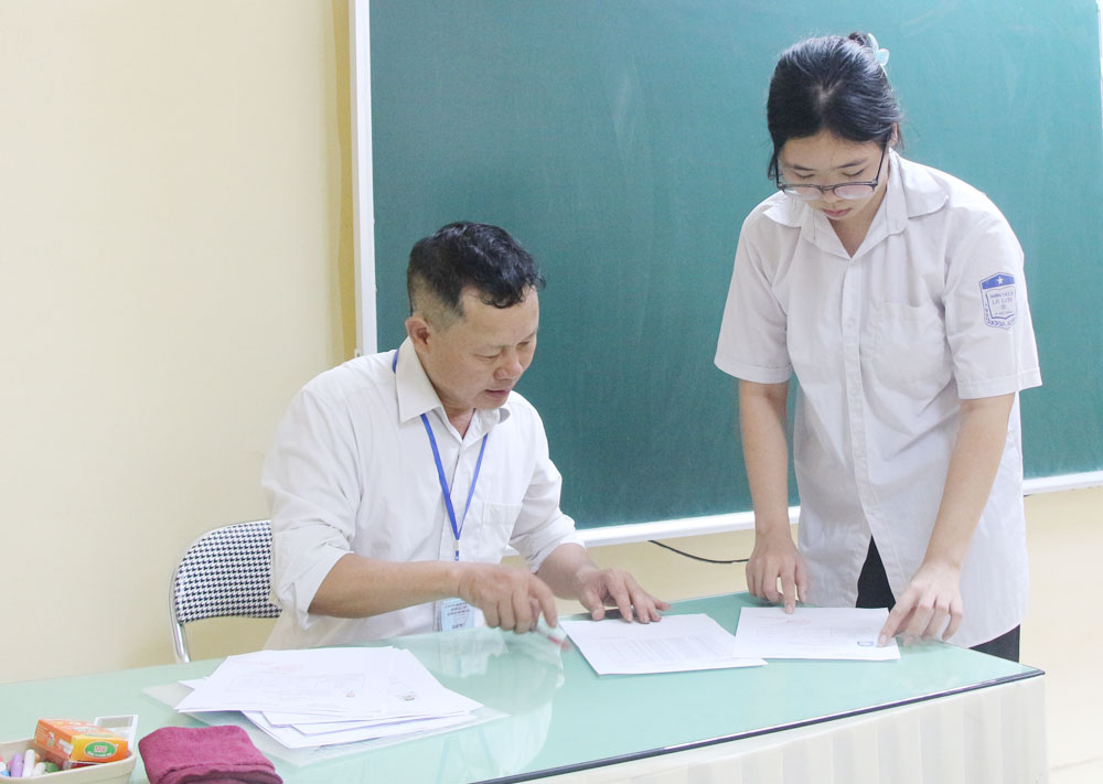 Giáo viên hướng dẫn thí sinh làm thủ tục chuẩn bị thi tại Hội đồng coi thi Trường Trung học phổ thông Ngô Sĩ Liên (thành phố Bắc Giang). Giáo viên hướng dẫn thí sinh làm thủ tục chuẩn bị thi tại Hội đồng coi thi Trường Trung học phổ thông Ngô Sĩ Liên (thành phố Bắc Giang).