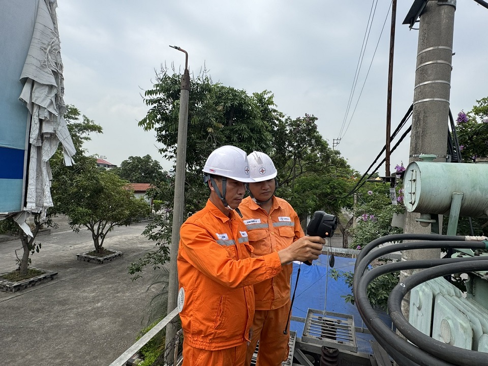 Anh Bùi Văn Tuyến cùng đồng nghiệp kiểm tra thông số kỹ thuật của thiết bị điện vào giờ cao điểm