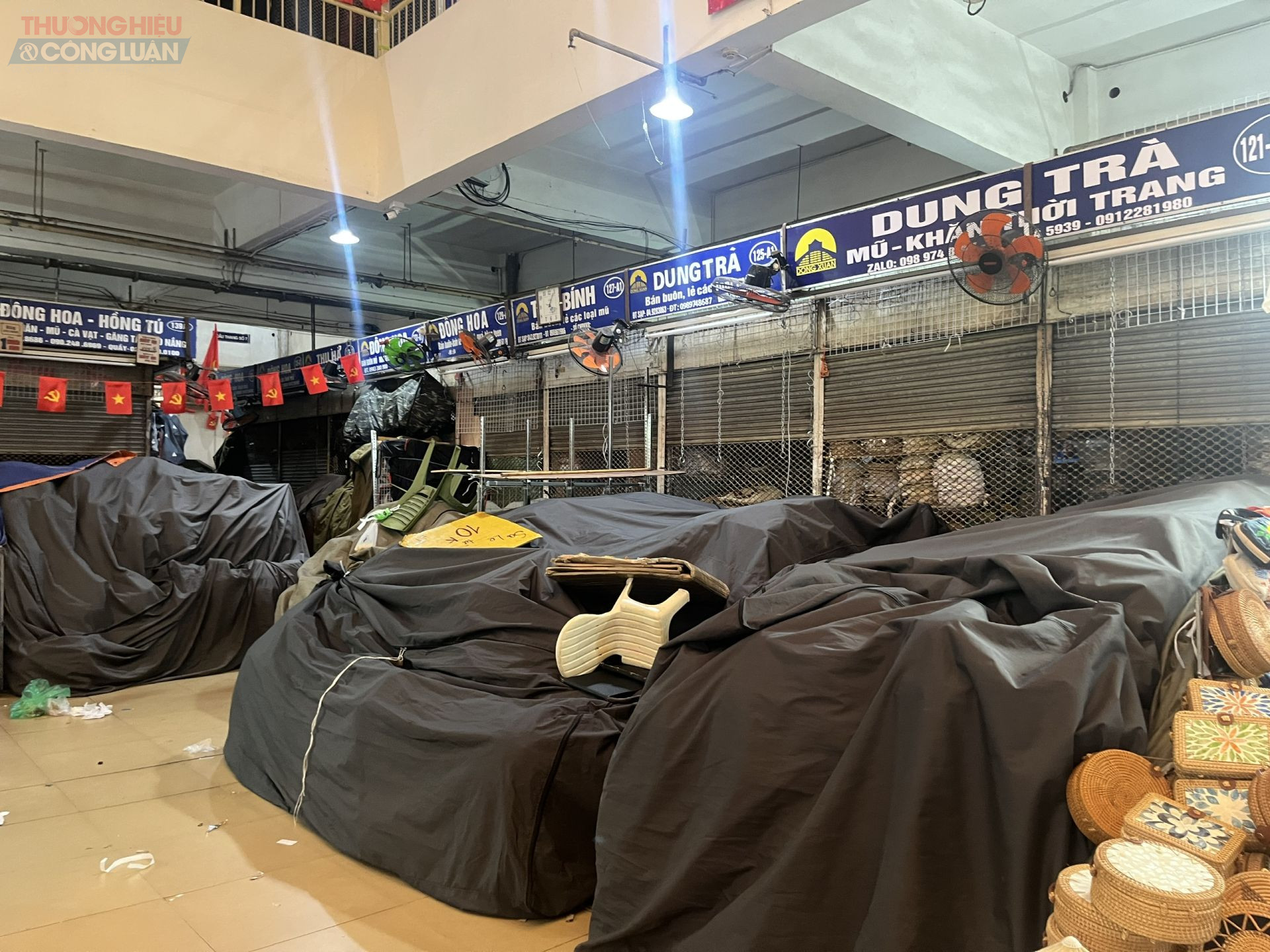 Tầng 1 của khu chợ, nơi tập trung các gian hàng thời trang như quần áo, giày dép, đã trong tình trạng đóng cửa suốt vài ngày qua. Một bảo vệ tại chợ chia sẻ rằng trước đây khu vực này vốn khá nhộn nhịp, không đến mức đìu hiu như hiện nay. 