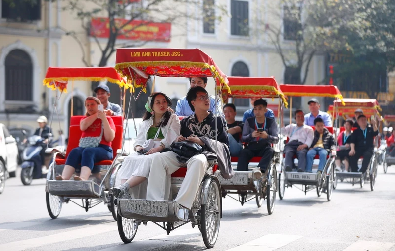 Du khách quốc tế trải nghiệm du lịch bằng xích lô quanh hồ Hoàn Kiếm, Hà Nội. Ảnh: Minh Quyết
