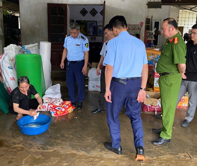 Hộ kinh doanh vi phạm tự tiêu hủy sản phẩm bột ngọt Ajinomoto, bột giặt OMO giả mạo nhãn hiệu dưới sự giám sát chặt chẽ của lực lượng chức năng tỉnh Yên Bái. Ảnh: Trần Quyên