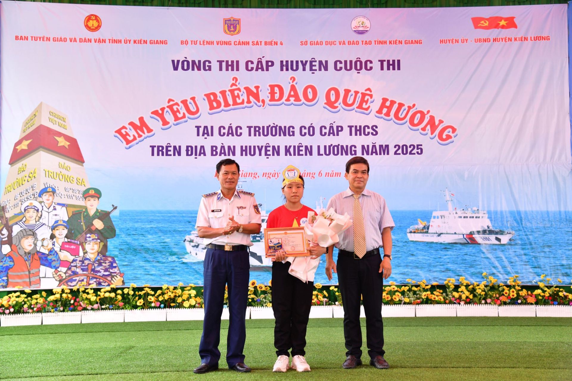 Đại tá Nguyễn Thái Dương, Phó Chính ủy Bộ Tư lệnh Vùng Cảnh sát biển 4 và đồng chí Thái Châu Báu, Phó Trưởng ban Tuyên giáo và Dân vận tỉnh Kiên Giang tặng giải nhất cho em Dương Ngọc Thảo Nguyên, học sinh lớp 6/3, Trường THCS Hòa Điền.