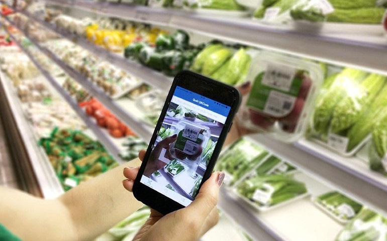 Người tiêu dùng truy xuất nguồn gốc thực phẩm bày bán tại siêu thị. (Ảnh: Báo Nhân Dân)