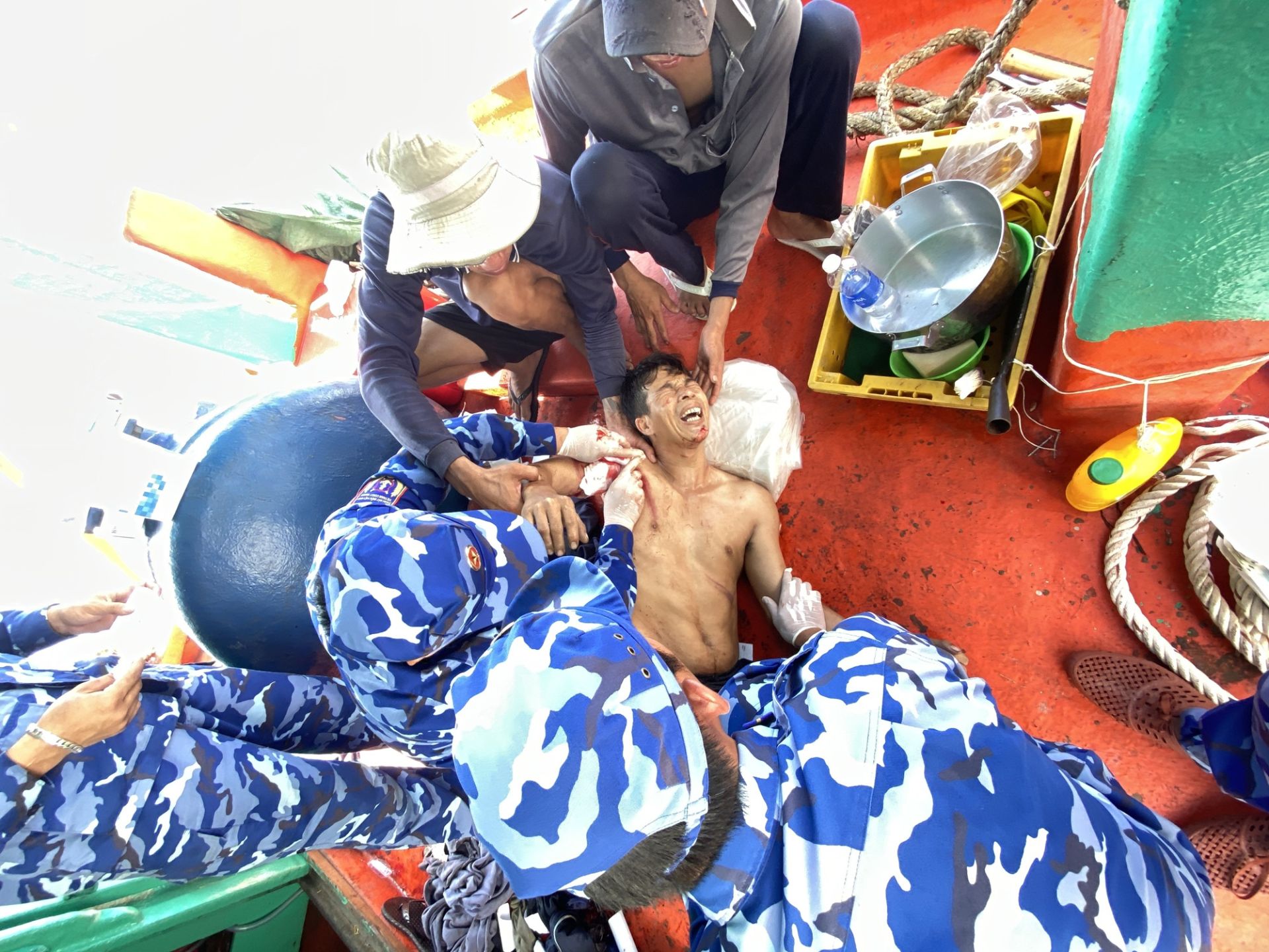 Cấn bộ, chiến sĩ Tàu 8021 tiến hành sơ cứu, băng bó viết thương cho ngư dân