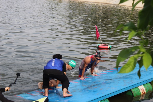 Các VĐV nam kết thúc bơi 750m chuyển tiếp sang đạp xe 20km và chạy bộ 5km