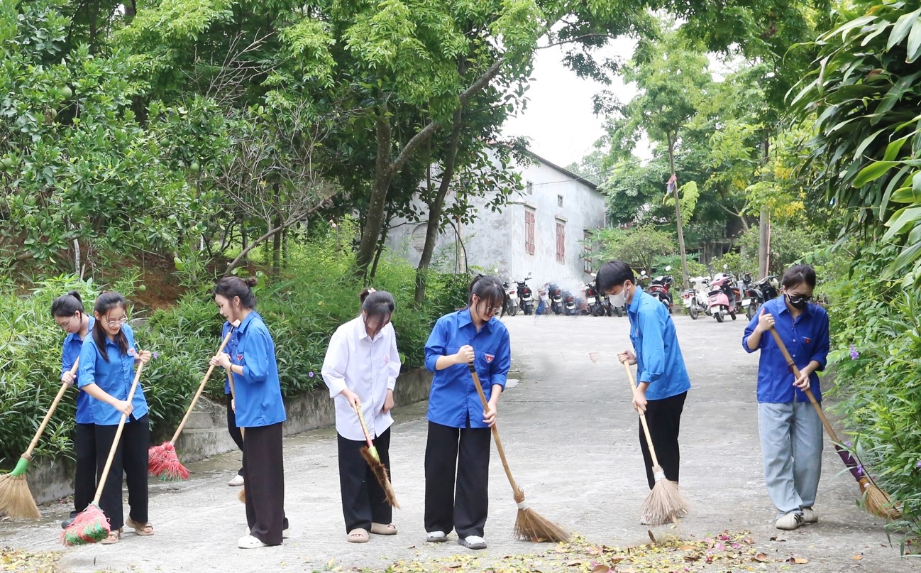 Các tình nguyện viên dọn dẹp tại khuôn viên Đền thờ Thái sư Lê Văn Thịnh.