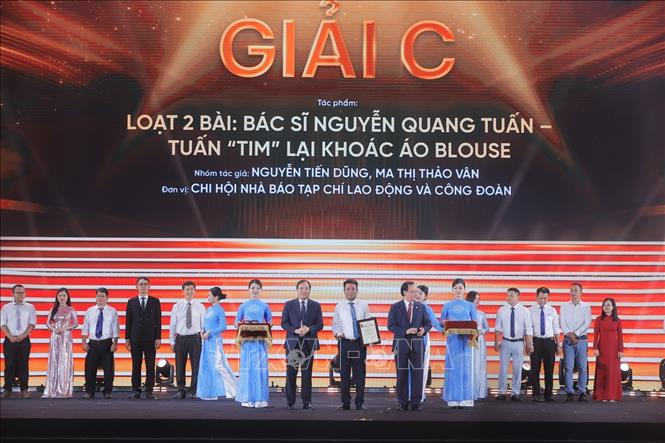 Tổng Biên tập Tạp chí Cộng sản Hoàng Trung Dũng và Tổng Giám đốc Đài Tiếng nói Việt Nam Đỗ Tiến Sỹ trao giải C cho các tác giả, nhóm tác giả đoạt giải. Ảnh: Minh Quyết/TTXVN