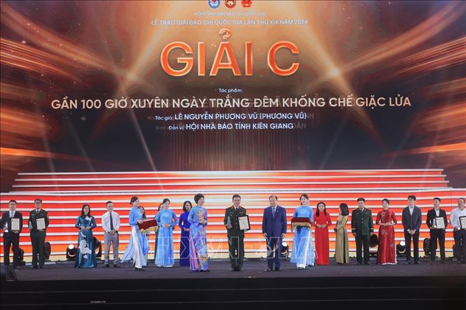 Tổng giám đốc TTXVN Vũ Việt Trang và Thứ trưởng Thường trực Bộ Văn hóa, Thể thao và Du lịch Lê Hải Bình trao giải C cho các tác giả, nhóm tác giả đoạt giải. Ảnh: Minh Quyết/TTXVN