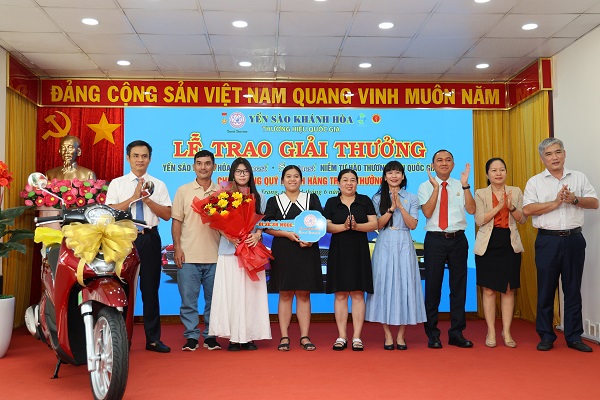 Ban lãnh đạo công ty trao thưởng cho khách hàng may mắn trúng thưởng.