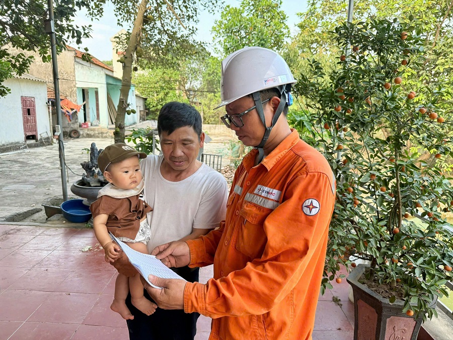 Công nhân Điện lực trực thuộc PC Thanh Hóa thông tin và giải đáp các thắc mắc của khách hàng về chỉ số công tơ của gia đình sau khi thực hiện kiểm tra đảm bảo khách quan, minh bạch và công khai