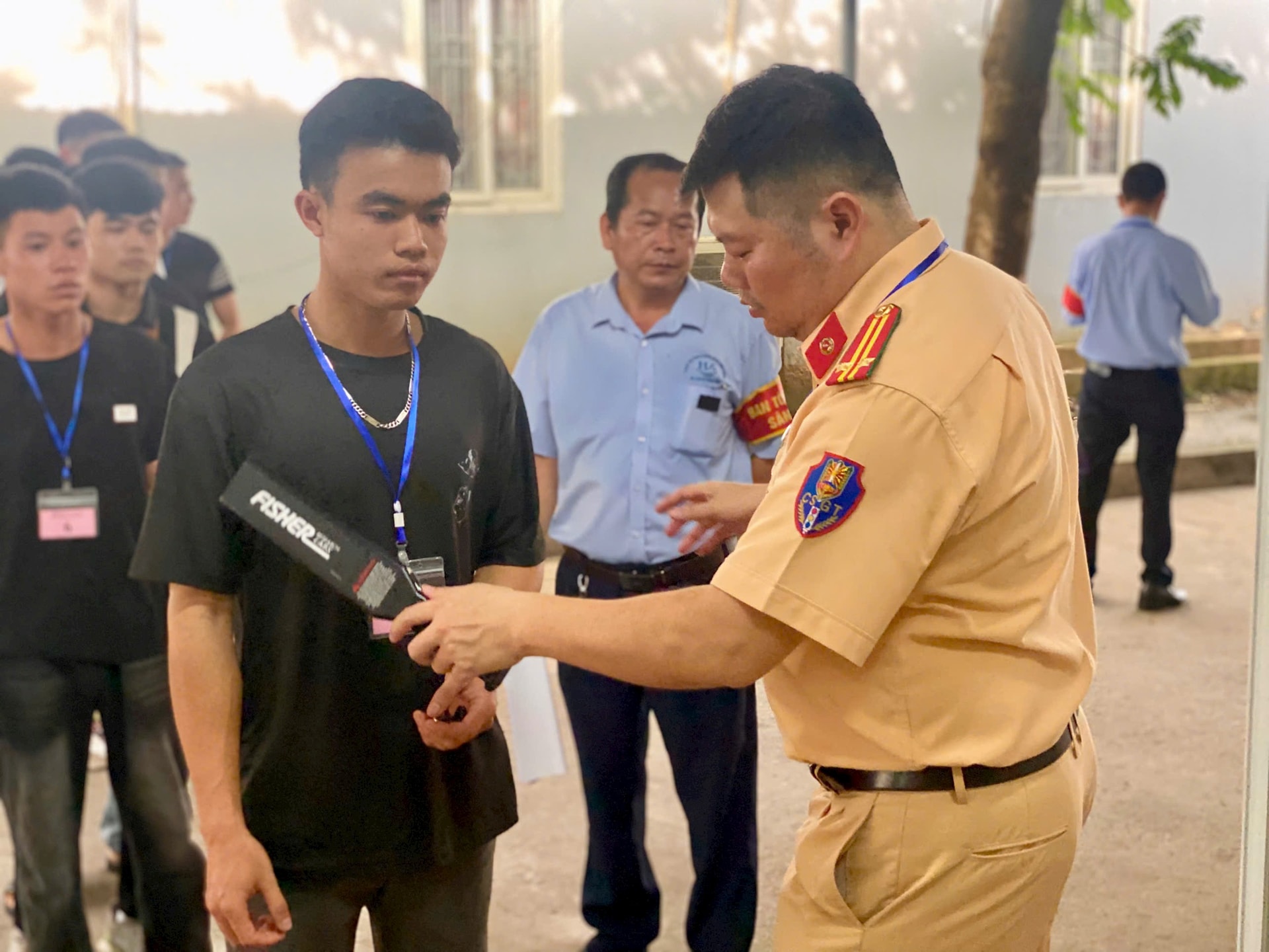 Cán bộ kiểm tra thí sinh, trước khi vào phòng thi lý thuyết. Ảnh: NT Cán bộ kiểm tra thí sinh, trước khi vào phòng thi lý thuyết. Ảnh: NT