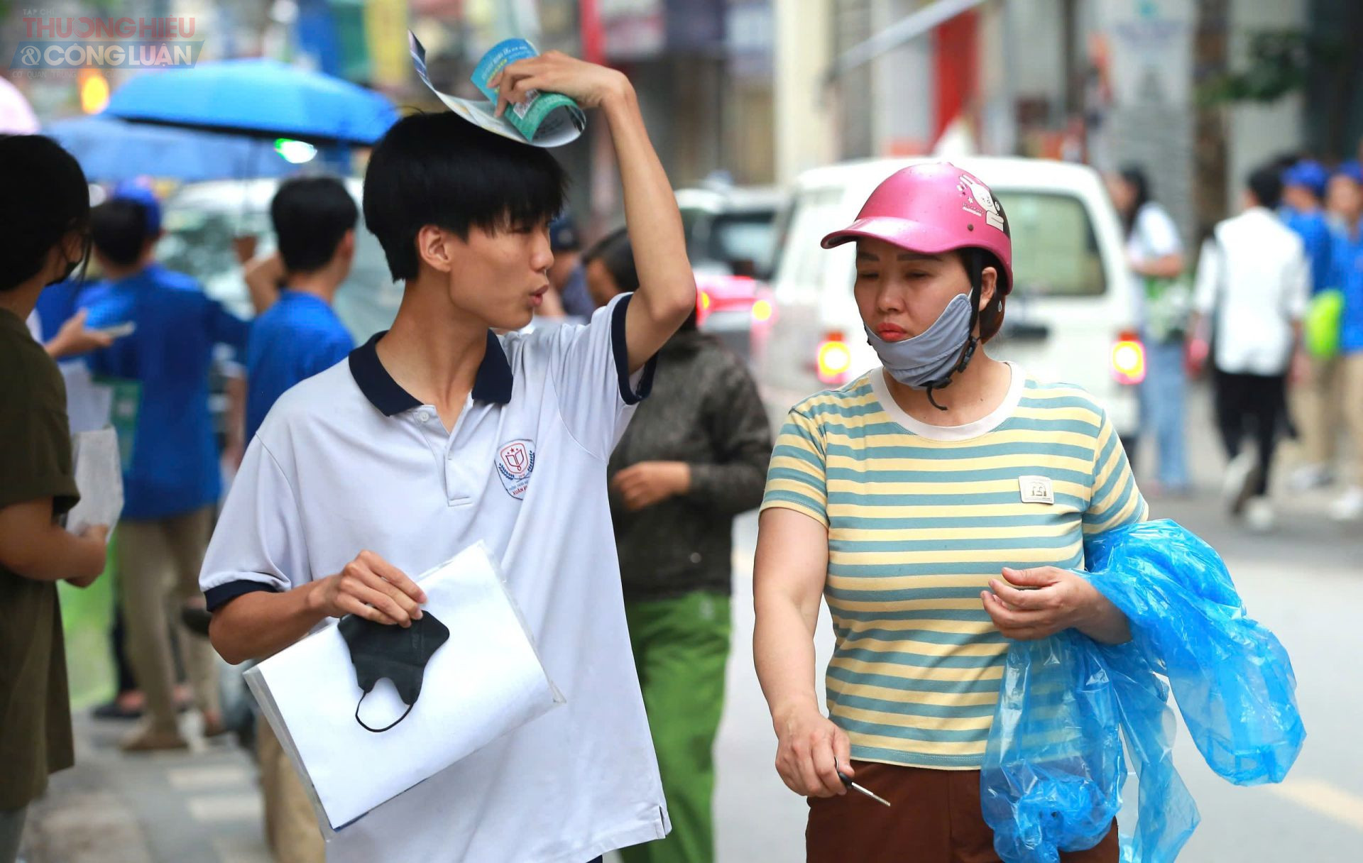 Hai thí sinh vội vã chạy tìm chỗ trú sau khi hết giờ thi môn.